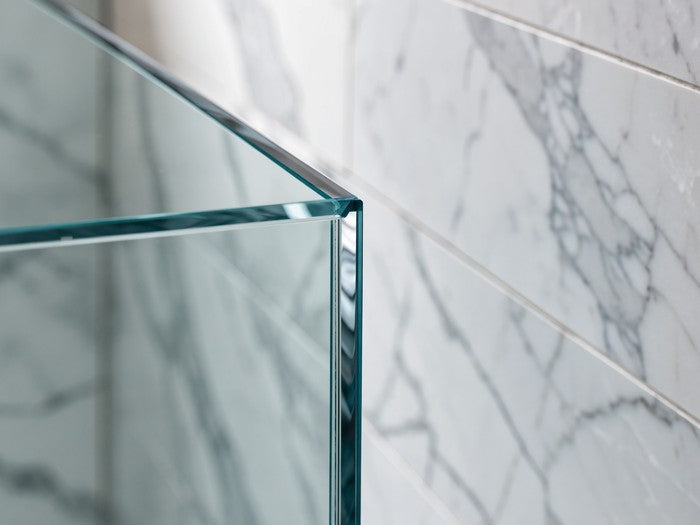 AI shot reference standing in for photography. A tiled shower. Tiled wall meeting the enclosure, a fresh white bead tooled into the corner.