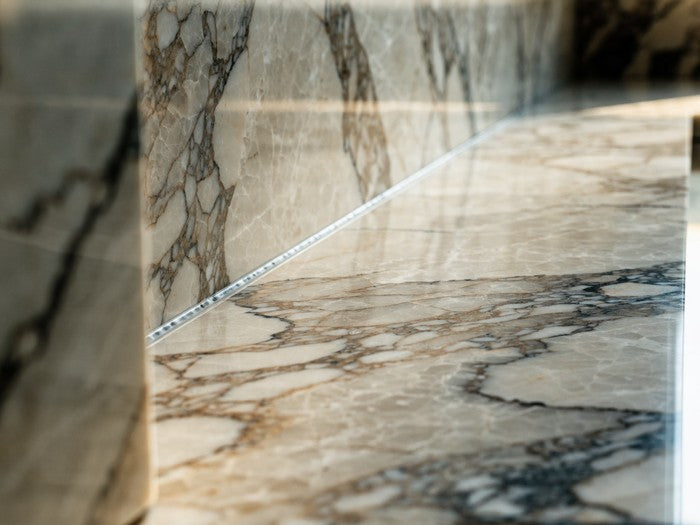 AI shot reference standing in for photography. A kitchen. Stone or tile backsplash meeting the counter, cured bead invisible.